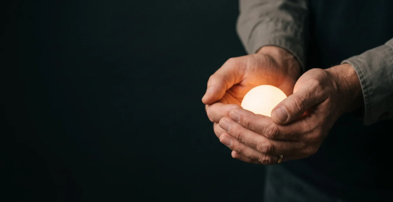 A parent's protective hand cupped gently around a soft glowing light, symbolizing guardianship of a child's online world